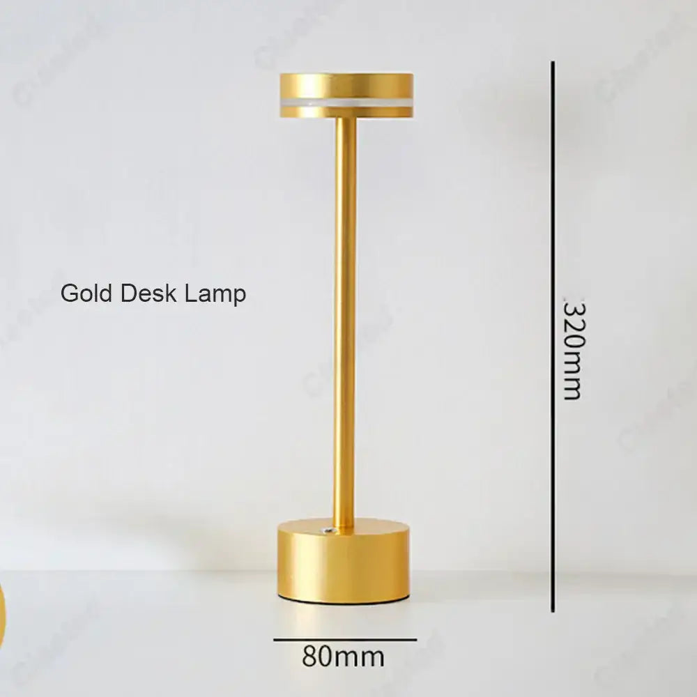 A sleek minimalist gold decorbites led touch table lamp with cylindrical base and slender stem for living room lighting