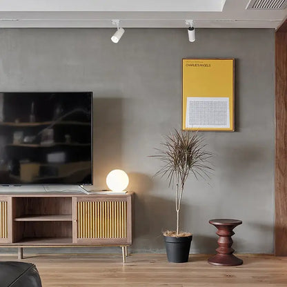 A sleek wooden tv console under a decorbites led track 7w cob rail spotlight for art exhibition and picture show
