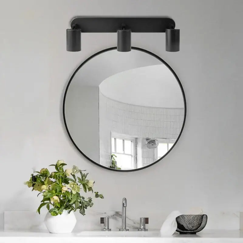 Black round mirror with minimalist frame mounted above sink complementing decorbites led track spot light for bedroom corridor