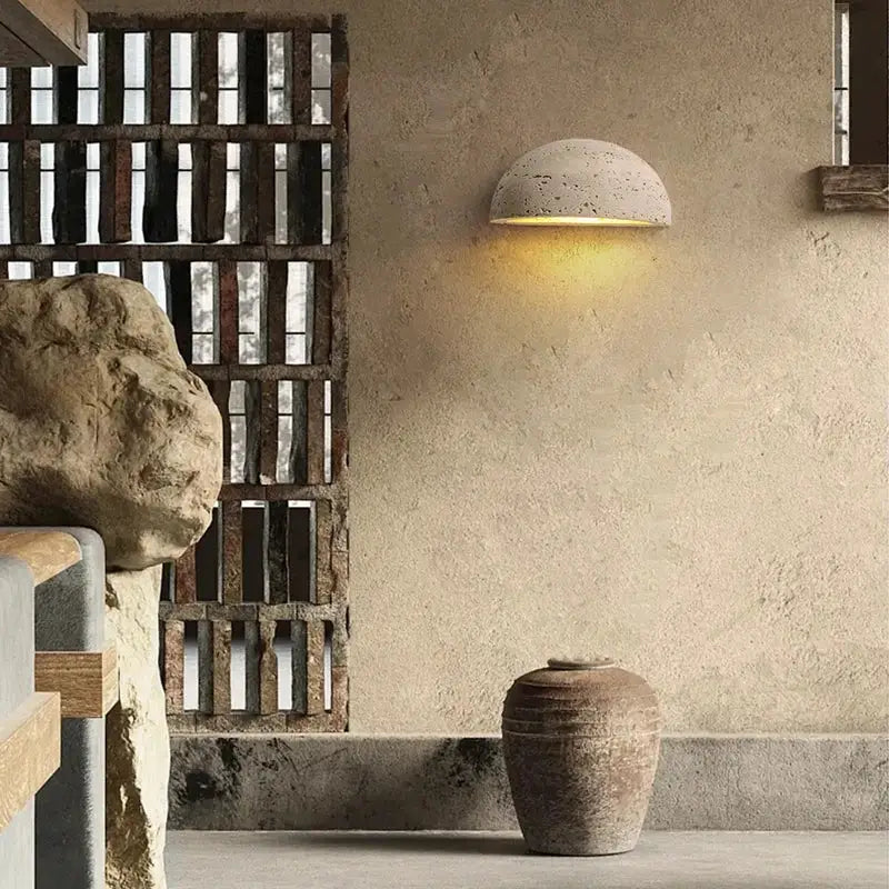 Half-spherical decorbites led travertine wall light with textured concrete finish emits warm natural yellow ambiance light