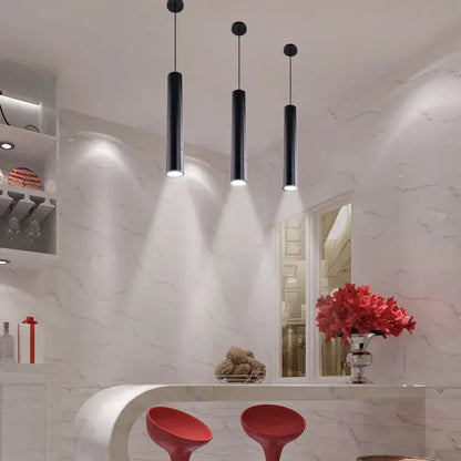 Three sleek black decorbites led tube pendant lights emit a soft glow for dining room and bar lighting