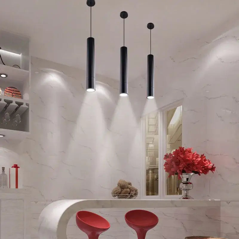 Three sleek black decorbites led tube pendant lights emit a soft glow for dining room and bar lighting
