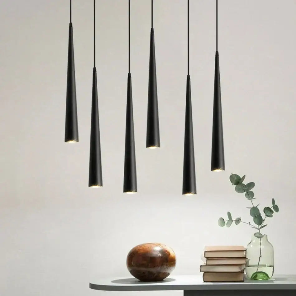 Five sleek black conical decorbites led tube pendant lights hang in a modern kitchen dining room arrangement