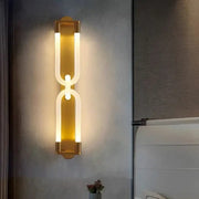 Modern gold-toned decorbites led tube wall sconce with sleek acrylic panels and black metal curved link design
