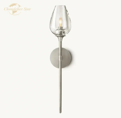 A sleek decorbites led tulip wall sconce with a clear glass shade and brushed nickel stem for indoor lighting