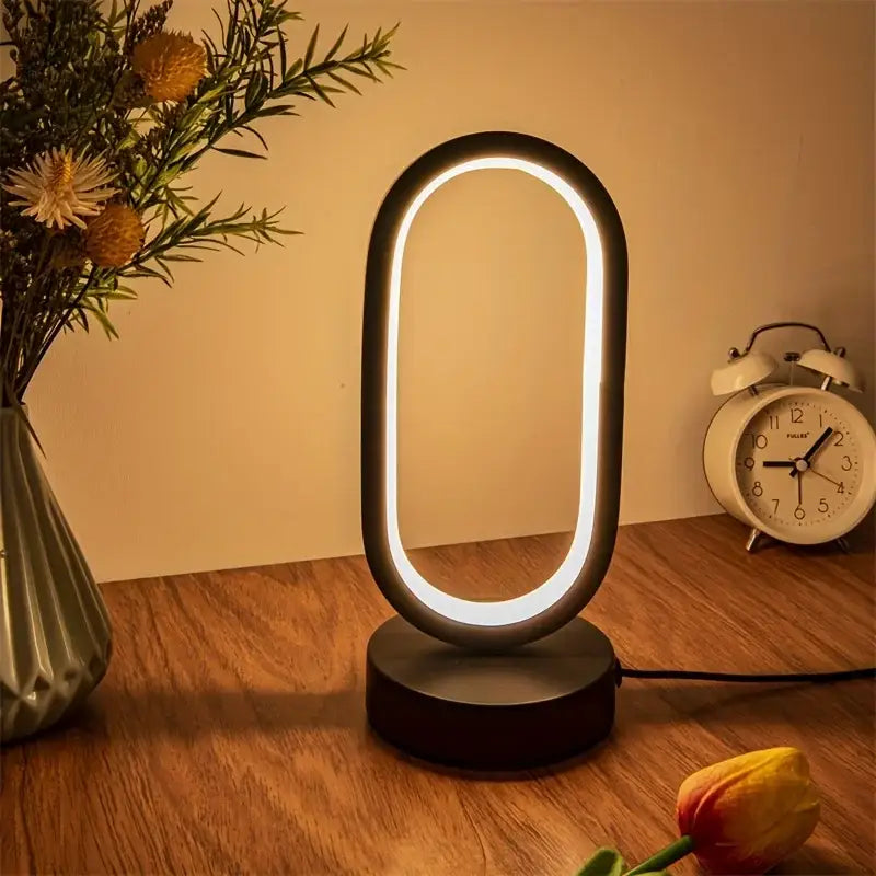 Modern black oval-shaped led lamp bedroom bedside decorative lamp with glowing white ring light for study or living room