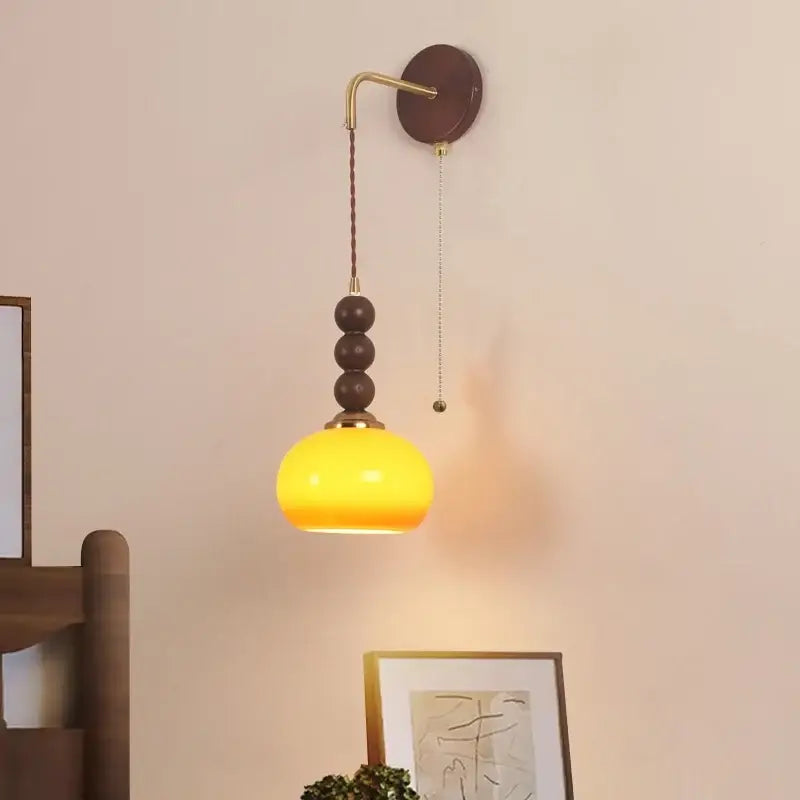 Warm yellow glass pendant light with brass accents and dark brown wooden beads for bedroom by Decorbites led wall