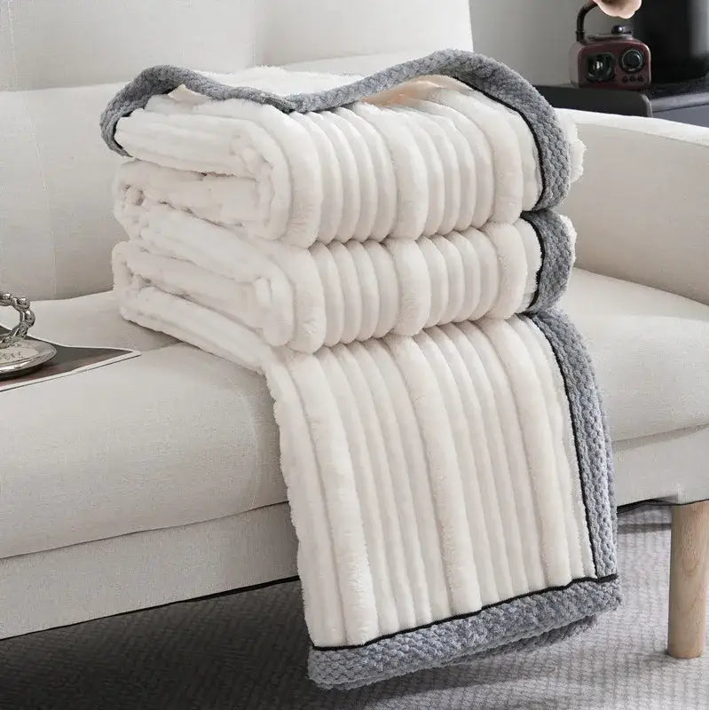 A cream-colored plush fleece decorbites light luxury sofa blanket with ribbed texture and gray knitted border