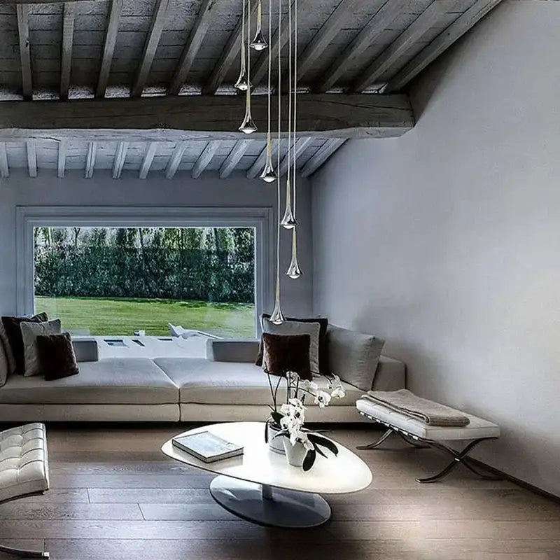 Modern white oval coffee table with sleek metallic base and glass top complements decorbites light luxury meteor chandelier