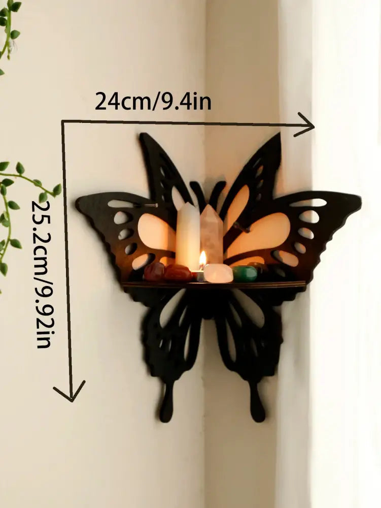 Black butterfly-shaped decorbites™ lotus floating wall shelf with cutout wings holding candles and stones on platform