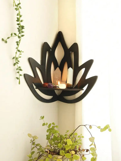 Black wooden lotus floating wall shelf with central platform holding candles and stones by DecorBites™