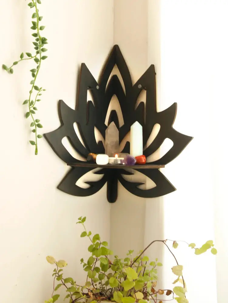 Black wooden lotus floating wall shelf with central horizontal slat holding candles and decorative items by DecorBites™