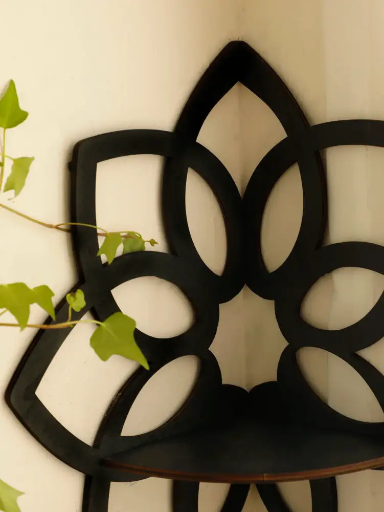 Black metal corner lotus floating wall shelf with floral cutout design for multi-style home decor by decorbites