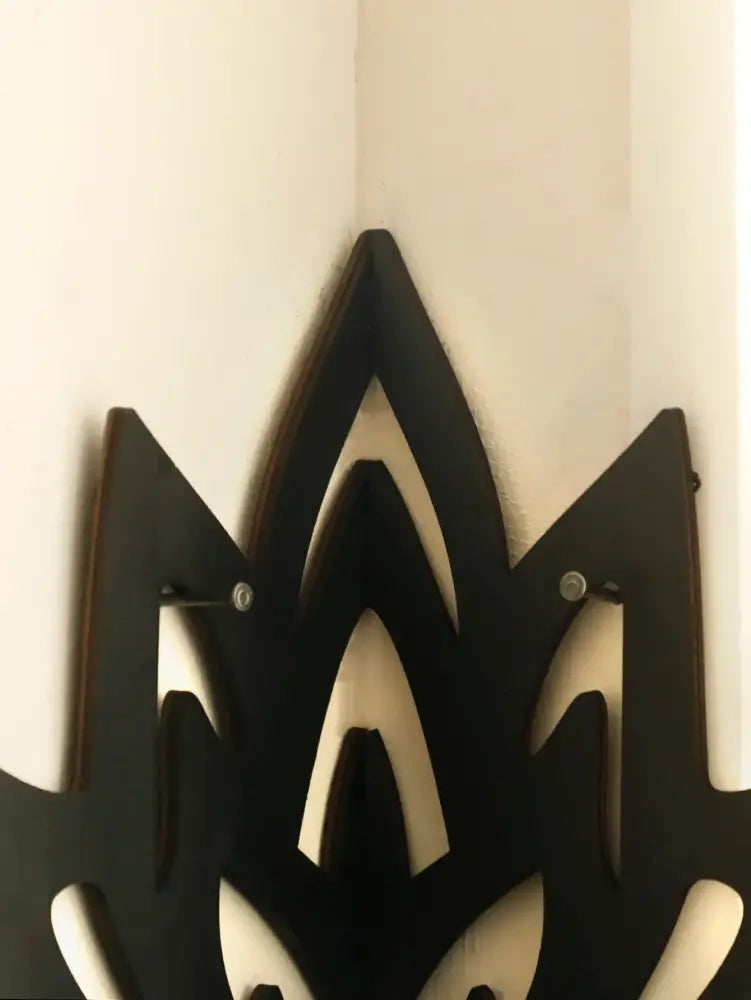 Black wooden lotus floating wall shelf featuring a stylized flame design for versatile home decor by DecorBites™