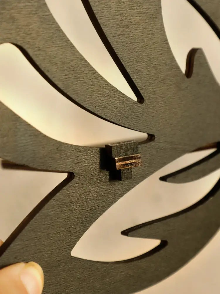 Decorbites™ lotus floating wall clock in black wood with white leaf cutouts and brass gear center as a floating wall shelf