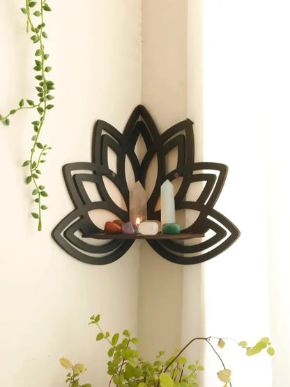 Black metal lotus floating wall shelf with central wooden slat displaying crystals and candles for home decor