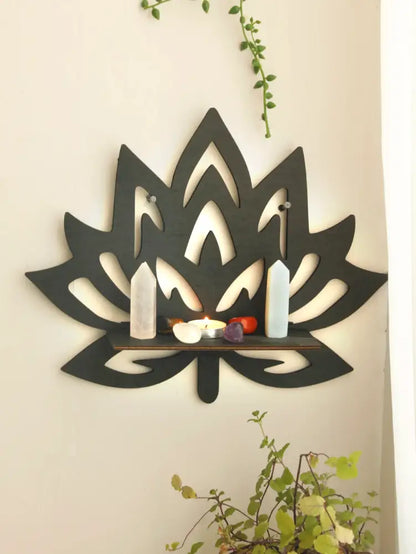 Black wooden lotus floating wall shelf with central slot holding crystals and decorative items by DecorBites™