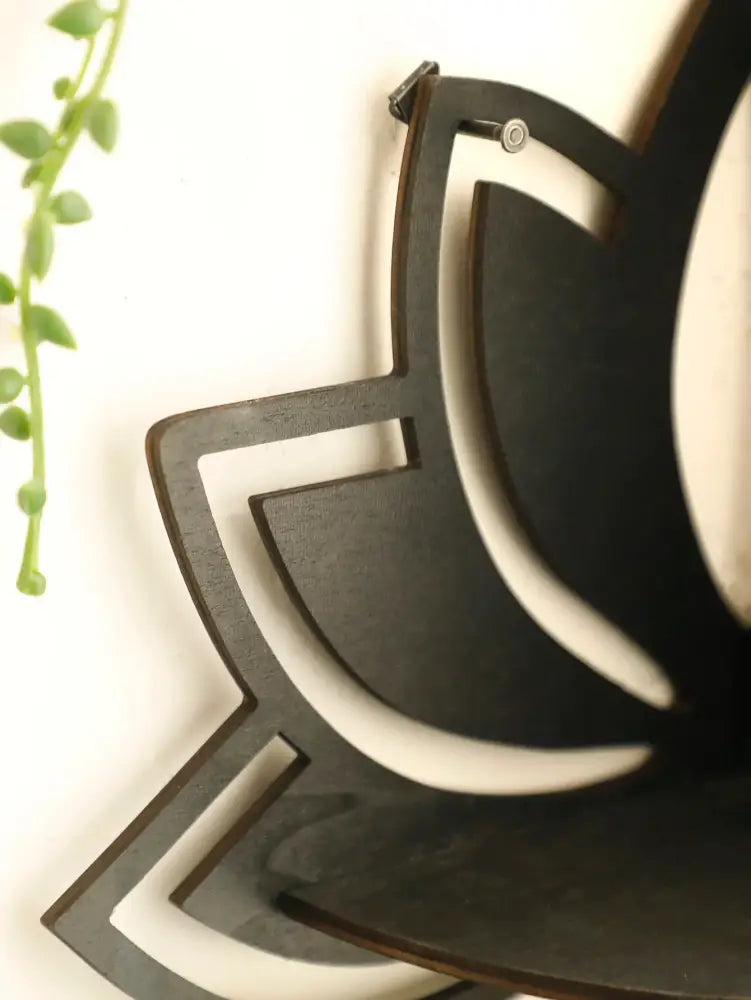 Black laser-cut wooden lotus floating wall art shaped like a stylized flower for decorbites floating wall shelf