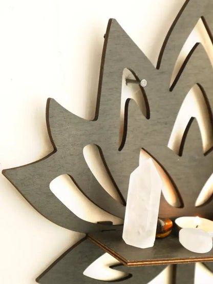 Gray laser-cut wooden lotus floating wall shelf featuring a small shelf with white quartz and candles for decor