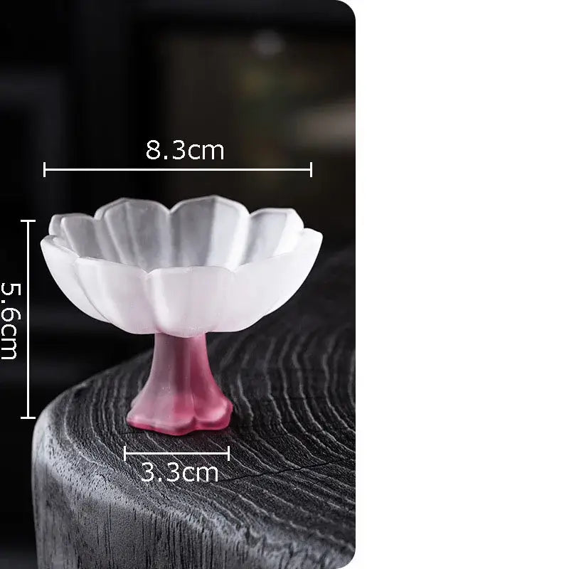 A delicate white ceramic decorbites lotus flower dish with a pink stem shaped like an open lotus flower