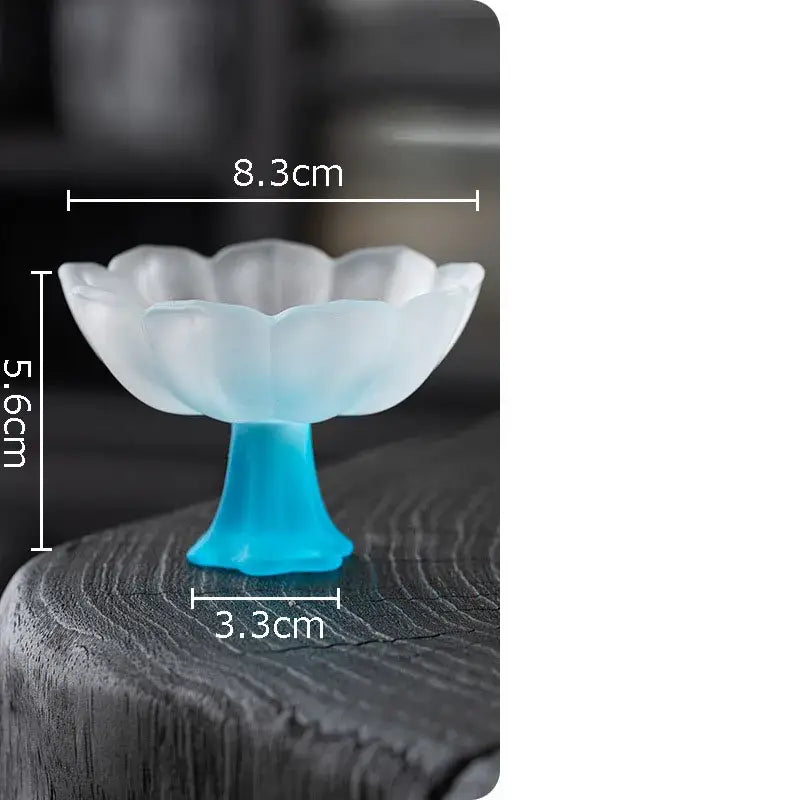 A translucent light blue lotus flower glass dessert bowl with a fluted rim and solid turquoise pedestal base by decorbites lotus flower