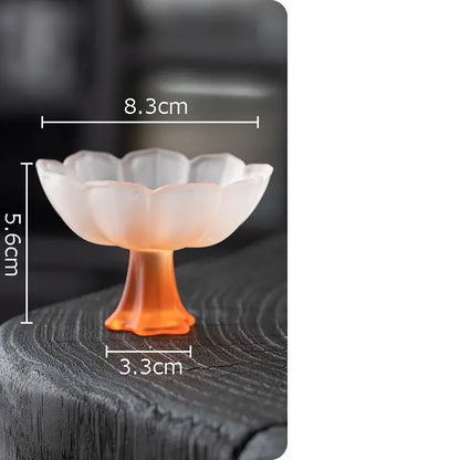 A translucent peach-colored lotus flower glass dessert bowl with fluted rim and orange-tinted stem by decorbites lotus flower