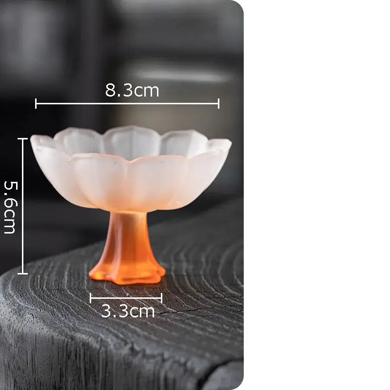 A translucent peach-colored lotus flower glass dessert bowl with fluted rim and orange-tinted stem by decorbites lotus flower