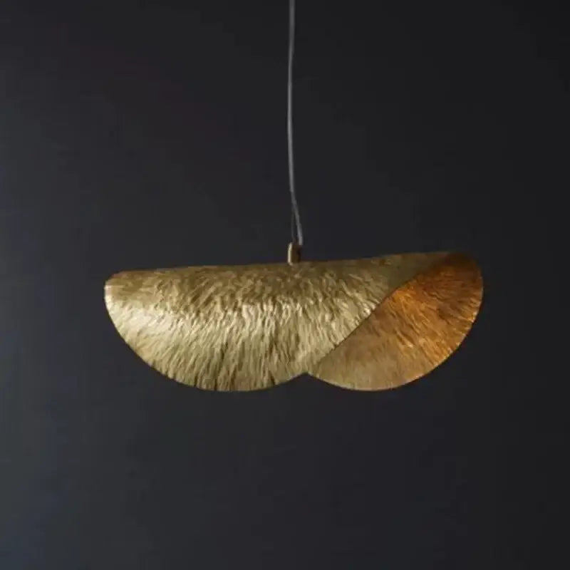 A modern gold-toned DecorBites lotus flower pendant light with textured curved fan design for dining room and hotel decor