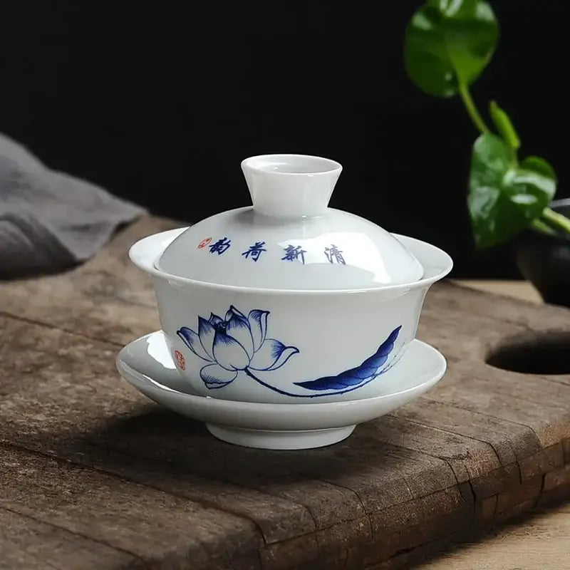 White porcelain gaiwan tea set with blue hand-painted lotus design and chinese characters on the lid from decorbites lotus