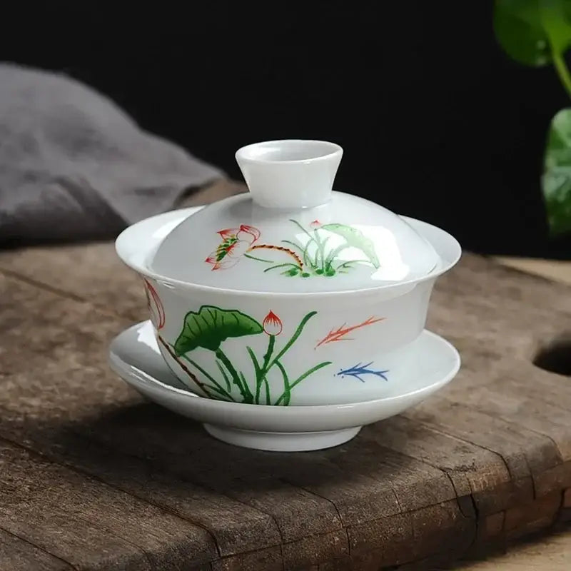 White porcelain gaiwan tea set with hand-painted lotus and reed design in green red and blue decorbites lotus