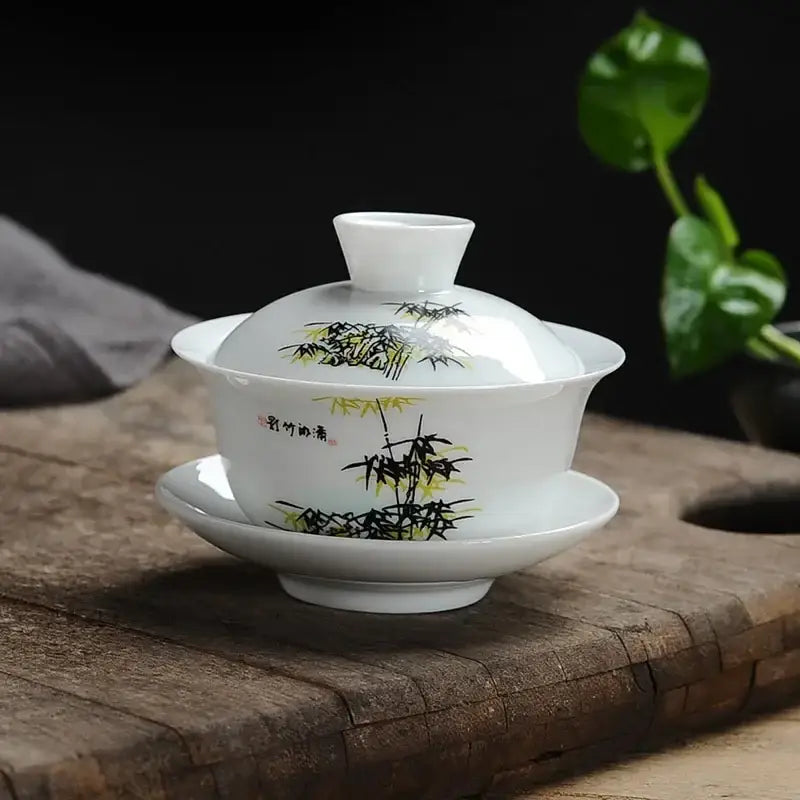 White porcelain gaiwan tea set with hand-painted black and yellow bamboo design and chinese calligraphy decorbites lotus