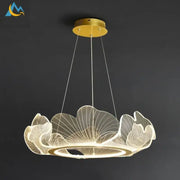A modern gold-toned DecorBites lotus leaf pendant light with translucent acrylic leaves emitting warm glow