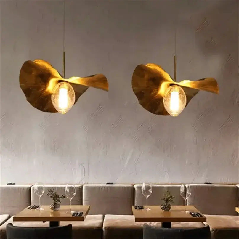 Golden lotus leaf brass pendant lamp with exposed bulbs by decorbites lotus leaf hangs above dining area