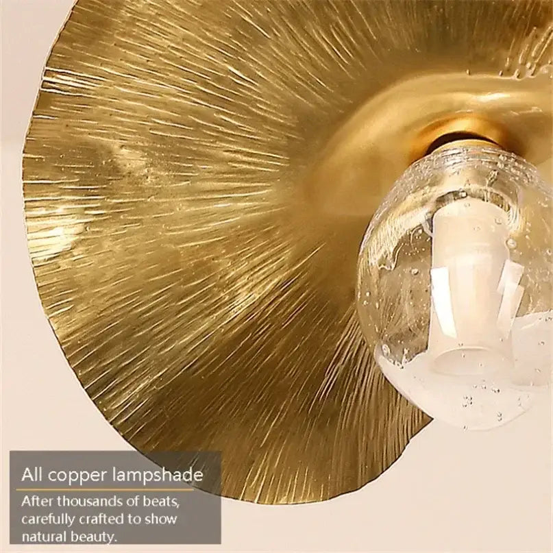 Gold-colored copper pendant lamp with textured radiating pattern and clear bulb decorbites lotus leaf brass design