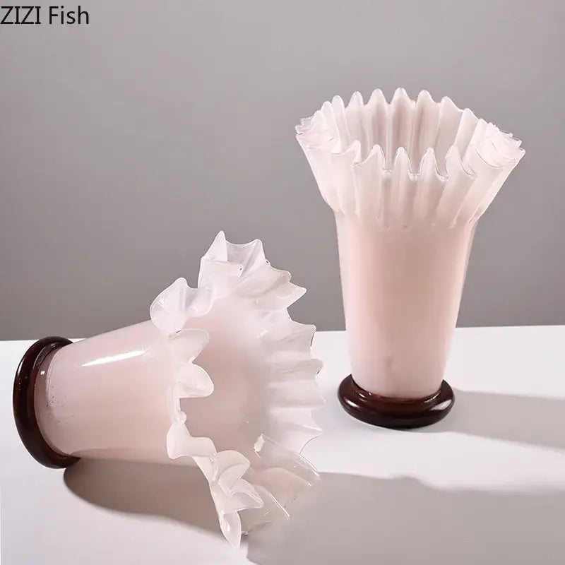 Pink frosted glass vases with lotus leaf edge ruffled rims and dark brown wooden bases for room decor