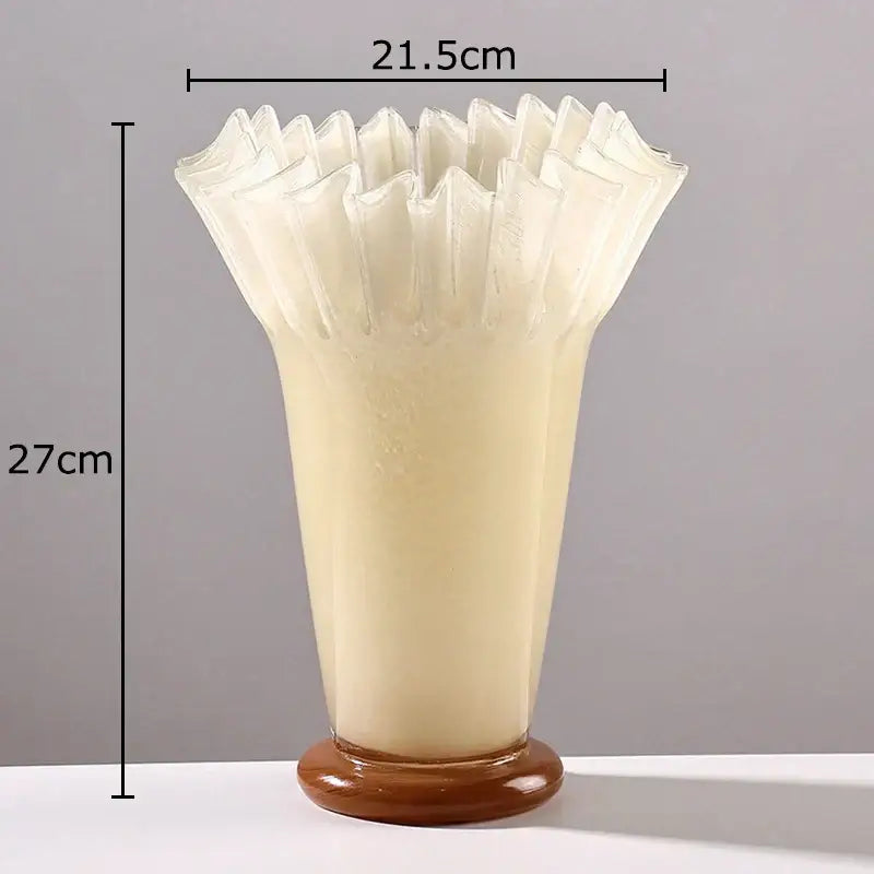 Cream-colored glass vase with a lotus leaf edge fluted rim and rounded brown base for table flower arrangement
