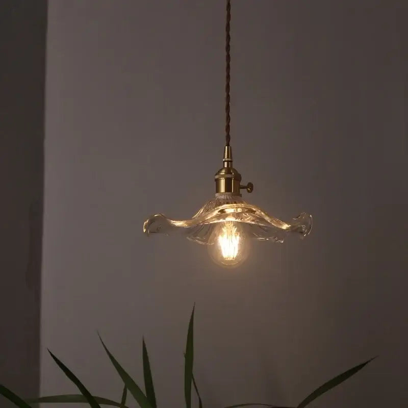 Warm-toned lotus leaf glass pendant light from DecorBites with brass fixture and twisted cord for loft and dining areas
