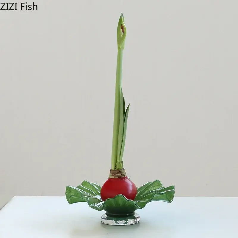 A glossy red ceramic amaryllis bulb with green stems in a decorbites lotus leaf glass vase as an elegant centerpiece
