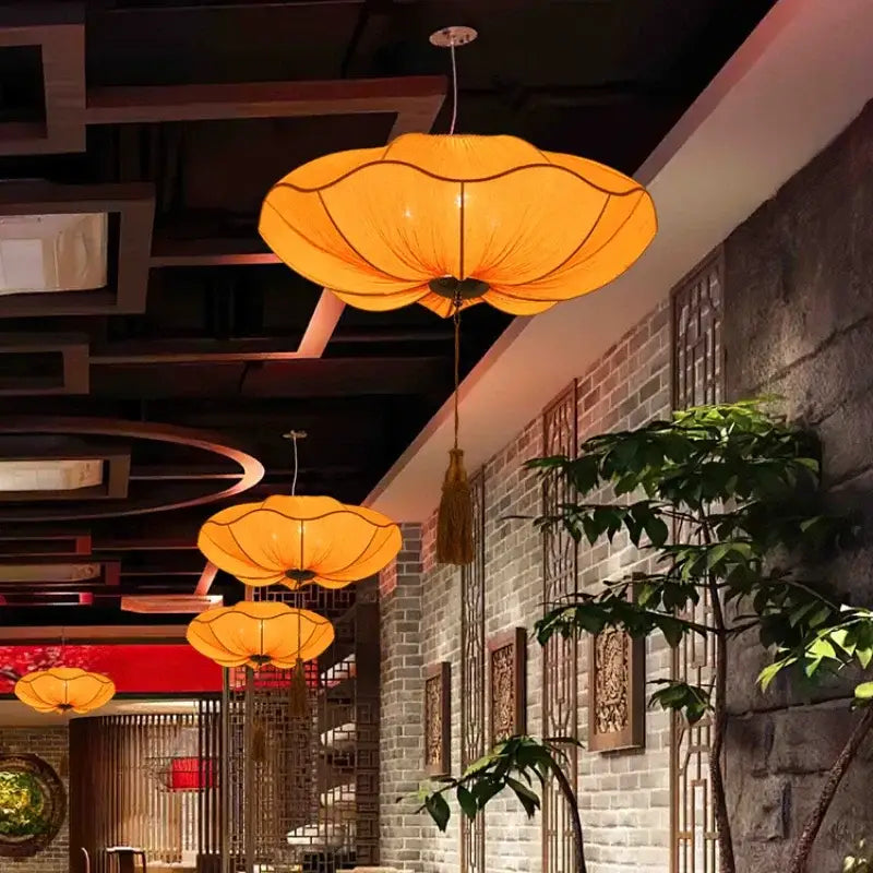 Orange lotus-shaped pendant light with translucent fabric shade and tassel by decorbites lotus leaf lantern for kitchen use