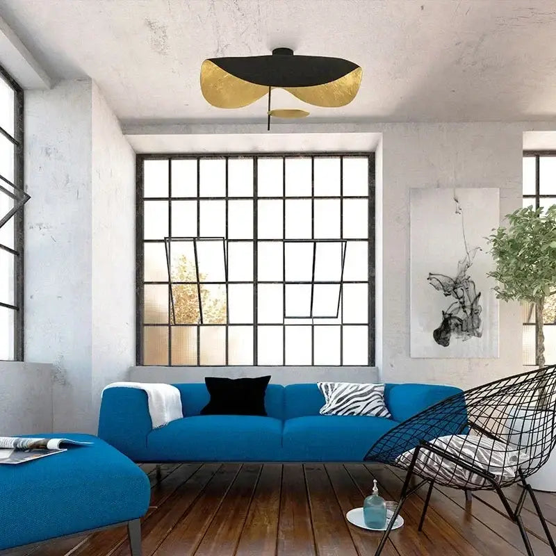 Vibrant blue sectional sofa with black and zebra-print throw pillows under decorbites lotus leaf led ceiling chandelier black white