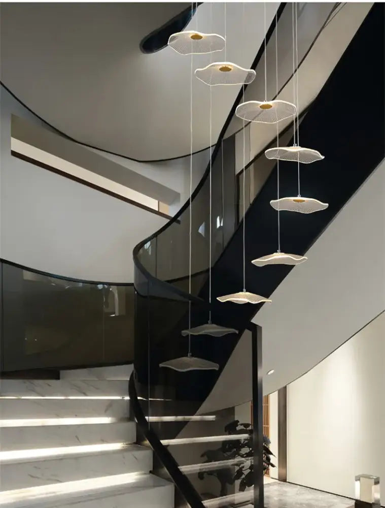 Modern white pendant lights with gold centers in a cascading decorbites lotus leaf led chandelier above staircase