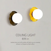 Two decorbites lotus leaf wall lamps with circular white led bulbs on matte gold and vibrant yellow leaf-shaped bases