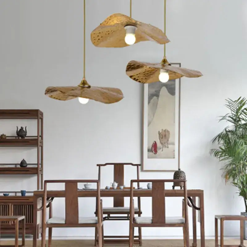 Three golden lotus leaf pendant lights with textured finish hanging from brass cords by decorbites pendant light