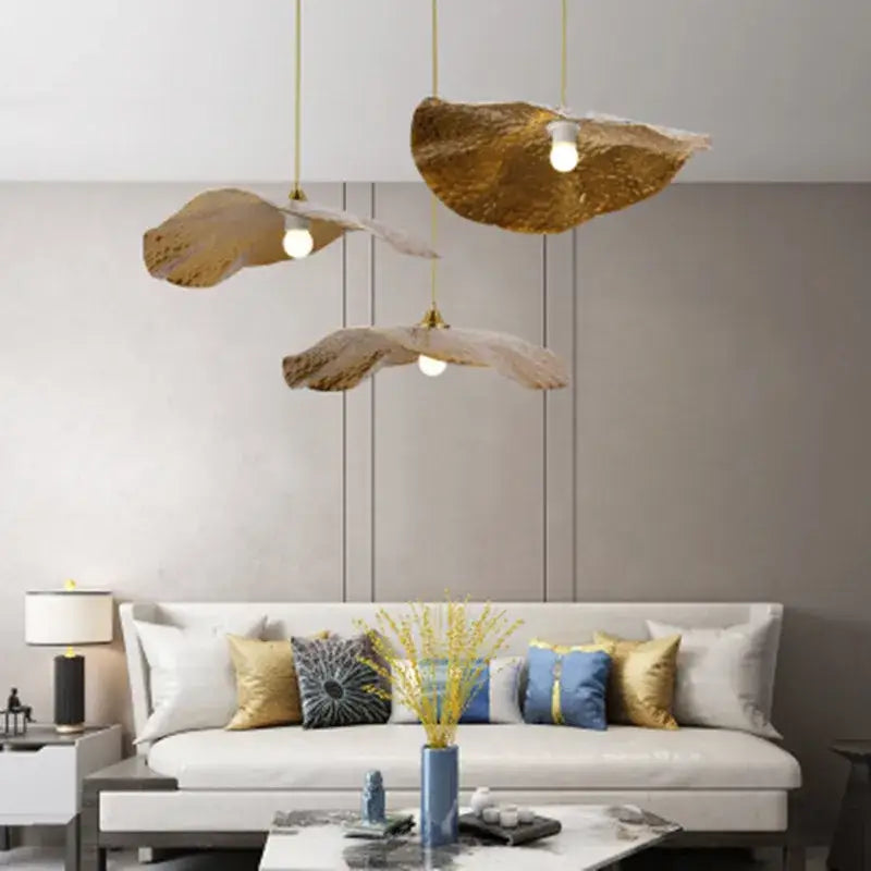 Three golden leaf-shaped decorbites lotus leaf pendant lights hang elegantly for home and cafe lighting