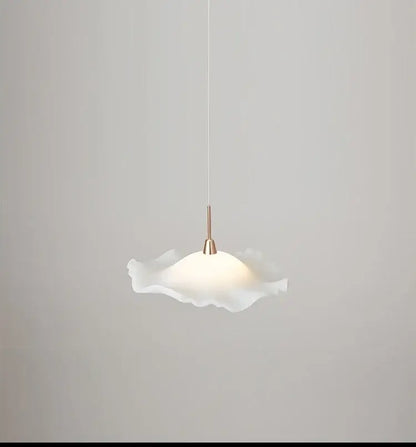 A white frosted glass decorbites lotus leaf pendant light with ruffled edges and a brass-finished stem for modern spaces