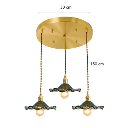 Gold-toned decorbites lotus leaf pendant lights with three dark green ruffled glass shades suspended by twisted bronze cords