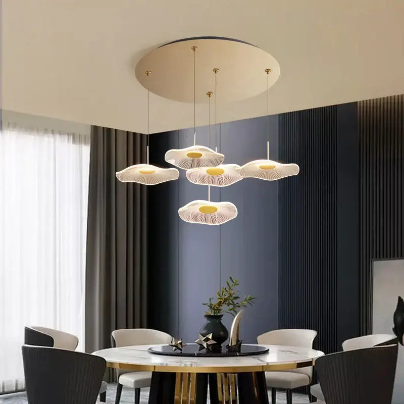Modern mushroom-shaped pendant lights with cream translucent material and golden centers in lotus leaf tea chandelier
