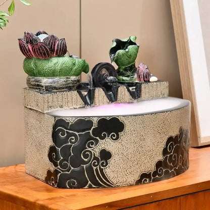 Decorbites lotus leaf water feature with beige textured base black cloud motifs and green lotus leaves for feng shui decor