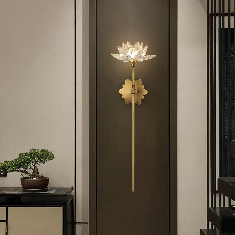 A delicate gold-toned DecorBites Lotus LED wall lamp with a crystal lotus flower head and petal-shaped base