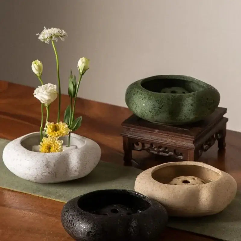 A decorbites™ lotus seedpod ceramic vase set featuring four stone sand incense burners in earthy tones with central holes